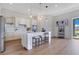 Bright kitchen featuring a large island with barstool seating, stainless appliances, and wood flooring at 13461 Panama Beach Ct, Orlando, FL 32827