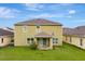 Backyard view featuring a well-maintained lawn, patio, and neutral-colored exterior at 144 Williamson Dr, Davenport, FL 33897
