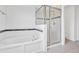 Bathroom featuring a tiled shower, soaking tub, and tiled walls, illuminated by natural light at 144 Williamson Dr, Davenport, FL 33897