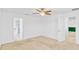 Spacious bedroom with a ceiling fan, beige carpet, and views into other rooms at 144 Williamson Dr, Davenport, FL 33897