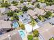 An aerial view of a two-story house with grey shingles, solar panels, white driveway, and a backyard pool with an enclosure at 14423 Tambourine Dr, Orlando, FL 32837