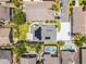 Aerial view of a property showcasing a well-kept backyard, solar panels, green grass, and surrounding neighborhood homes and driveways at 14423 Tambourine Dr, Orlando, FL 32837