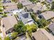 An elevated shot capturing a house featuring solar panels on the gray roof, surrounded by lush greenery and neighborhood homes at 14423 Tambourine Dr, Orlando, FL 32837