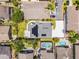 An aerial view of a house, showing its perimeter, and its grey shingles, solar panels, green lawn, and the street in front at 14423 Tambourine Dr, Orlando, FL 32837