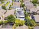 Aerial view of a well-maintained house featuring a grey roof with solar panels, green lawn, and a fenced-in yard with tropical plants at 14423 Tambourine Dr, Orlando, FL 32837
