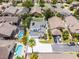 Aerial shot showcases a house featuring well-maintained landscaping, a white driveway, grey roof with solar panels, and a lush neighborhood at 14423 Tambourine Dr, Orlando, FL 32837