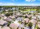 Picturesque neighborhood aerial view with homes, tree-lined streets, a tranquil lake, and a golf course creating a peaceful setting at 14423 Tambourine Dr, Orlando, FL 32837
