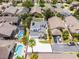 An aerial view of a property boundary, white driveway, solar panels on a grey roof, and manicured landscaping, surrounded by neighborhood homes at 14423 Tambourine Dr, Orlando, FL 32837