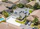 Aerial view of a home showcasing the backyard pool, well-maintained landscaping, and driveway at 14423 Tambourine Dr, Orlando, FL 32837