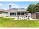 Well-manicured backyard featuring a lush lawn, patio, solar panels, and ample space for outdoor activities at 14423 Tambourine Dr, Orlando, FL 32837