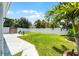 Lush backyard with green grass, concrete patio, mature trees, and privacy fence at 14423 Tambourine Dr, Orlando, FL 32837