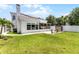 Expansive backyard with a lush lawn, patio, solar panels, and mature trees providing shade at 14423 Tambourine Dr, Orlando, FL 32837