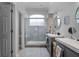 Bathroom featuring double sinks, tiled shower, and an arched window providing natural light at 14423 Tambourine Dr, Orlando, FL 32837