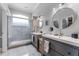 Bathroom with double sinks, modern lighting, and a glass-enclosed shower for a sleek design at 14423 Tambourine Dr, Orlando, FL 32837