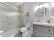 Bathroom featuring frosted glass shower doors, a vanity, a round mirror and light walls at 14423 Tambourine Dr, Orlando, FL 32837