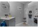 Half bathroom with a modern sink, mirror, and view into the hallway and staircase at 14423 Tambourine Dr, Orlando, FL 32837