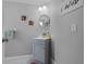 Cozy half bathroom featuring stylish lighting, a round mirror, and a functional sink at 14423 Tambourine Dr, Orlando, FL 32837