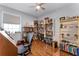 Home office featuring hardwood floors, a large window, and ample shelving at 14423 Tambourine Dr, Orlando, FL 32837