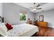 Bedroom featuring a ceiling fan, a bed, wood floors, and a window at 14423 Tambourine Dr, Orlando, FL 32837