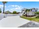 Two story home featuring an attached two car garage, neutral paint, decorative brick detail, and tropical landscaping at 14423 Tambourine Dr, Orlando, FL 32837