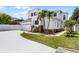 Two story home featuring an attached two car garage, neutral paint, decorative brick detail, and tropical landscaping at 14423 Tambourine Dr, Orlando, FL 32837