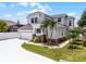 Two story home featuring an attached two car garage, neutral paint, decorative brick detail, and tropical landscaping at 14423 Tambourine Dr, Orlando, FL 32837