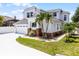 Two story home featuring an attached two car garage, neutral paint, decorative brick detail, and tropical landscaping at 14423 Tambourine Dr, Orlando, FL 32837