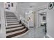 Staircase adjacent to foyer with view of front entry and bedroom, with decorative lighting and tile flooring at 14423 Tambourine Dr, Orlando, FL 32837