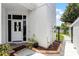 Charming front entry featuring a brick paver walkway and covered porch with white door and decorative wreath at 14423 Tambourine Dr, Orlando, FL 32837