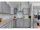 Modern kitchen with gray cabinets, granite countertops, stainless steel appliances, and a stylish backsplash at 14423 Tambourine Dr, Orlando, FL 32837
