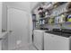 Well-organized laundry room featuring modern washer and dryer, ample shelving, and a convenient pet door at 14423 Tambourine Dr, Orlando, FL 32837
