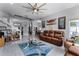 Spacious living room with comfortable leather seating, a unique ceiling fan, and a stylish blue area rug at 14423 Tambourine Dr, Orlando, FL 32837