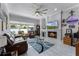 Bright living room featuring tile floors, fireplace, large windows, ceiling fan, and comfortable leather furniture at 14423 Tambourine Dr, Orlando, FL 32837