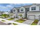 View of the townhomes with modern farmhouse design, white siding, garages, and tidy landscaping at 1462 Brookdale Ct, Oviedo, FL 32765