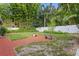 Landscaped backyard features a brick patio, lush greenery, and privacy fence, creating a serene outdoor space at 1519 N Westmoreland Dr, Orlando, FL 32804
