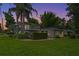 Well-maintained home with a lush lawn and tropical landscaping against a vibrant sunset at 1519 N Westmoreland Dr, Orlando, FL 32804