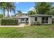 Charming home boasts a vibrant turquoise front door, lush landscaping, and well-manicured lawn at 1519 N Westmoreland Dr, Orlando, FL 32804