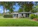 Charming home with a manicured lawn, mature trees, and a welcoming turquoise front door at 1519 N Westmoreland Dr, Orlando, FL 32804