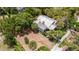 Aerial view of a home, highlighting the private backyard, mature trees, and proximity to brick roads at 16103 Denham Ct, Clermont, FL 34711