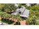 Aerial view of a home with a distinctive architectural design, brick street, and mature palm trees at 16103 Denham Ct, Clermont, FL 34711