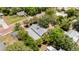 A home from above nestled amongst shady trees, located alongside a charming brick street and other residences at 16103 Denham Ct, Clermont, FL 34711