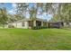 Well-maintained back yard with a screened-in patio and privacy hedges, ideal for relaxation and outdoor dining at 16103 Denham Ct, Clermont, FL 34711