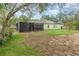 Back yard featuring solar panels on the roof, a screened enclosure, and a grass lawn at 16103 Denham Ct, Clermont, FL 34711