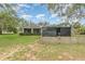 Back yard featuring a screened patio, fence, and a large tree at 16103 Denham Ct, Clermont, FL 34711