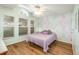 Light-filled bedroom with wood floors, ceiling fan, and decorative accent wall at 16103 Denham Ct, Clermont, FL 34711