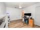 Office with wood floors, dual monitors, and storage shelves at 16103 Denham Ct, Clermont, FL 34711