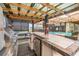 Outdoor kitchen, bar, hot tub, and seating at 16103 Denham Ct, Clermont, FL 34711