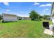 View of the backyard featuring green grass, trees, shed, and fence at 1647 Crestlawn Ave, Orlando, FL 32811