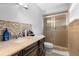Bathroom featuring a marble countertop vanity, tiled backsplash, and glass enclosed shower at 1647 Crestlawn Ave, Orlando, FL 32811