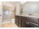 A well-lit bathroom with double sinks, a large mirror, and a glass-enclosed shower creates a spa-like feel at 178 Windflower Way, Oviedo, FL 32765